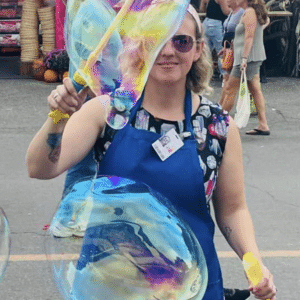 Cheerful lady playing with a bubble wand outside